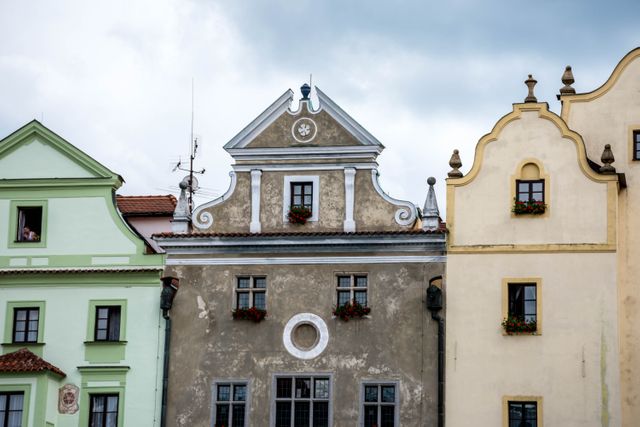 Capture of colorful historic buildings with beautiful facades in a European town's main square. Ideal for travel blogs, tourism brochures, history articles, and architecture magazines. Use to depict historical charm, cultural heritage, and the picturesque ambiance of old European towns.