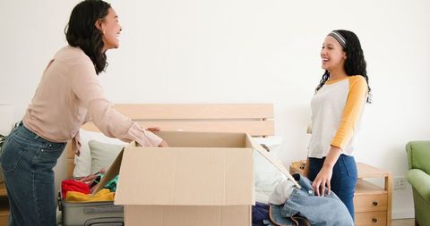 Mother and Daughter Packing for Family Trip at Home