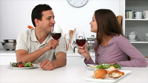 Couple Enjoying Romantic Dinner with Wine in Modern Kitchen