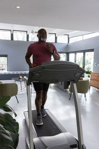 Senior Man Exercising on Treadmill in Stylish Living Room