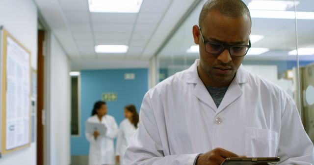 Focused Doctor Using Tablet in Hospital Corridor - Download Free Stock Images Pikwizard.com