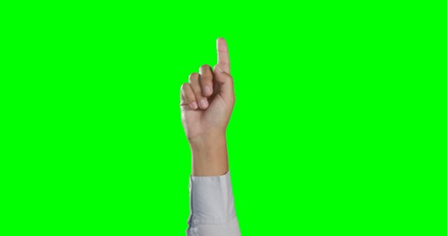 This image features a close-up of a hand pointing upwards with the index finger, against a green screen background. The hand is wearing a business casual white sleeve. Ideal for use in web design, presentations, promotional materials, and educational content to represent concepts such as direction, instruction, choosing, and touchscreen interaction.