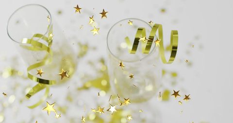 Festive champagne glasses with gold stars and streamers