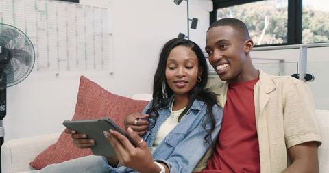 Happy Couple Relaxing at Home with Tablet Technology