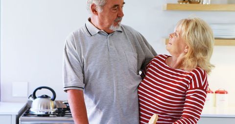 Senior Couple Sharing Joyful Moment in Bright Home Kitchen