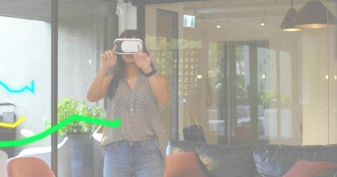Mideast woman using VR headset in modern coworking lounge with glass reflection and colored lines