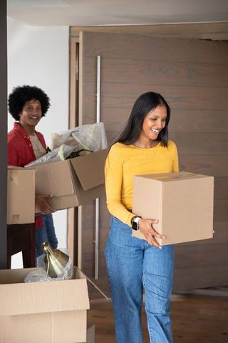Couple relocating into new home with cardboard boxes