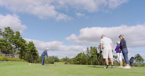 Group of friends enjoying golf on sunny day