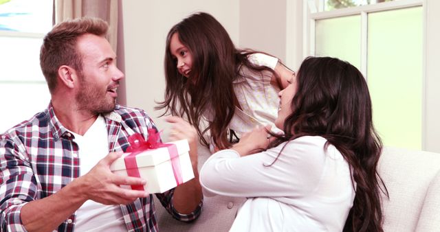 Cute girl surprising her parents with gift at home - Download Free Stock Photos Pikwizard.com