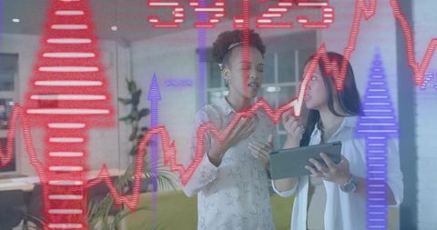 Businesswomen analyzing financial data on tablet with futuristic stock graph overlay