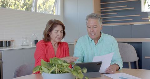 Senior couple using tablet for financial planning at home