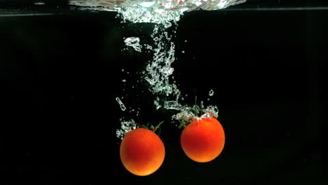 Tomatoes Plunging into Dark Water in Synchronized Splash