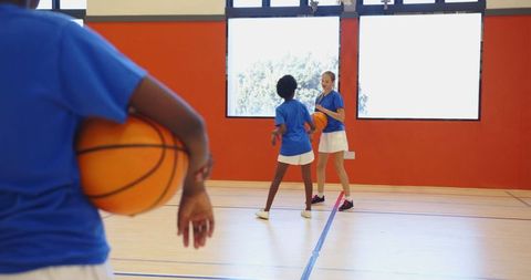 Diverse Middle School Girls Practicing Basketball in Gym