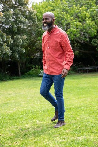 Confident Man Strolling Through Lush Green Backyard