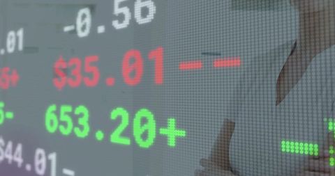 Businesswoman giving thumbs up beside led stock ticker showing market gains and confidence