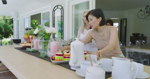 Women Enjoying Desserts and Drinks at Outdoor Celebration