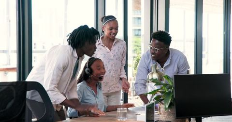 Diverse Team Celebrating Success with Technology in Modern Office