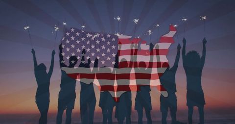 Group holding sparklers on beach at sunset with us flag map overlay for patriotic celebration