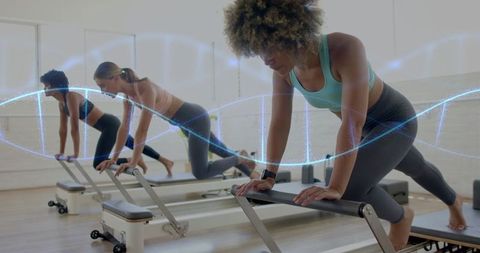 Diverse Women in Pilates Studio on Reformer Machines