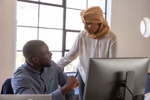 Diverse coworkers in modern office engaged in collaborative discussion