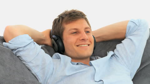 Casual Man Relaxing and Listening to Music on Couch
