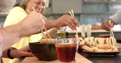 Friends Enjoying Spring Rolls and Asian Cuisine with Chopsticks - Download Free Stock Images Pikwizard.com