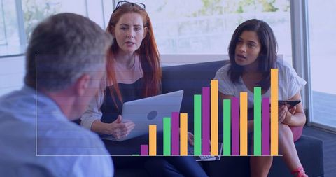 Team Collaborating in Modern Office Lounge with Interactive Bar Chart and Laptop Screen