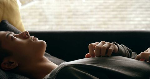 Young Biracial Man Relaxing on Couch in Tranquil Home Atmosphere