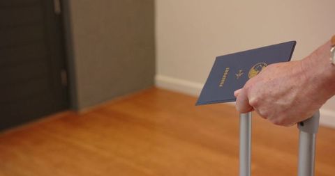 Senior traveler holding blue passport ready for adventure