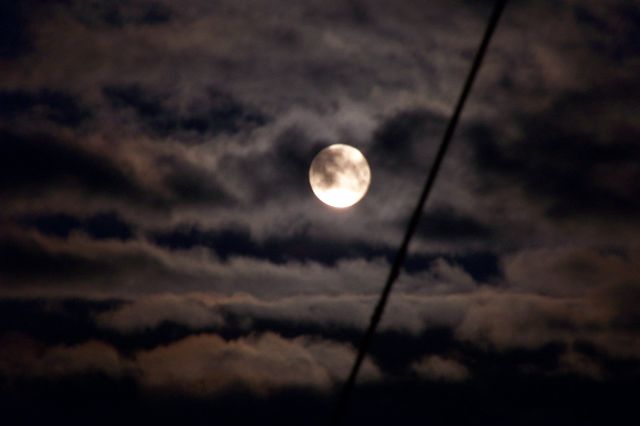 Full moon casting light through dark clouds creating an eerie atmosphere in the night sky. Ideal for use in projects related to nature, astronomy, nocturnal themes, or adding a mysterious or spooky touch to backgrounds and presentations.