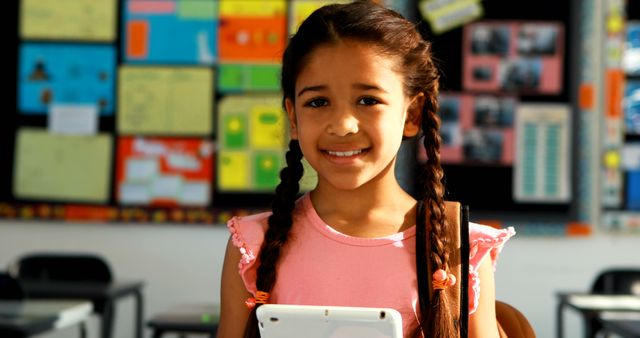 Smiling girl with tablet in colorful classroom - Download Free Stock Images Pikwizard.com