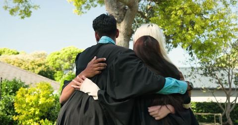 Diverse Friends Celebrating Graduation Outdoors with Embrace