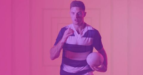 Male Rugby Athlete Holding Ball in Studio with Modern Pink Overlay