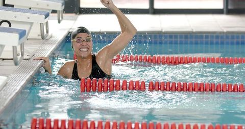 Female athlete celebrating in swimming pool after successful race