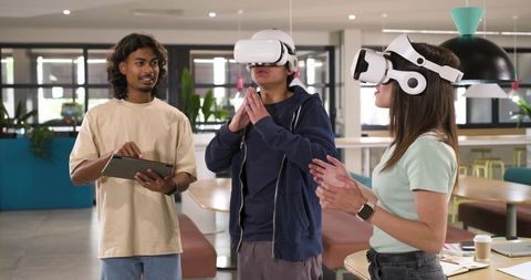 Young African American Professionals Testing VR Headsets in Collaborative Office Space