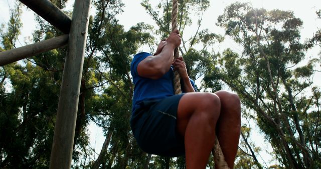 Determined Young Man Climbing Rope Outdoors in Natural Setting - Download Free Stock Images Pikwizard.com