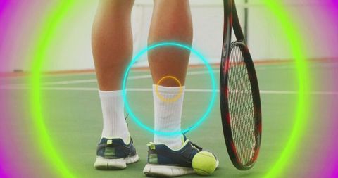 Tennis player standing with racket on neon-lit court