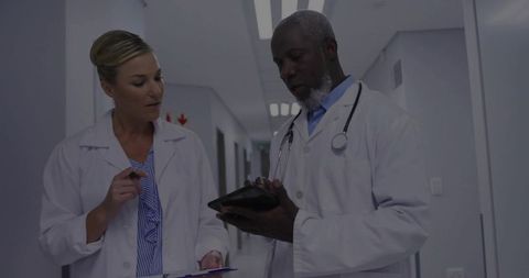 Doctors Using Tablet for Efficient Patient Consultation in Hospital Corridor