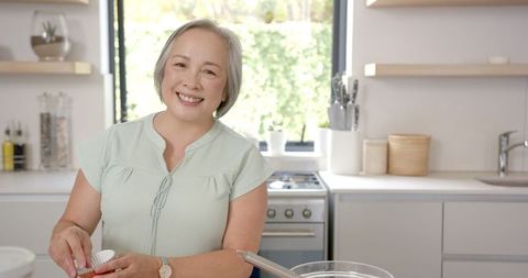 Smiling Woman Baking Cupcakes in Modern Kitchen