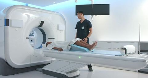 African american patient receiving ct scan in modern radiology suite with technician
