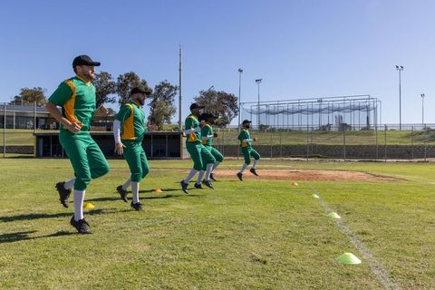 Baseball Team Performing High-Knee Drills on Field for Preseason Training and Warm-up