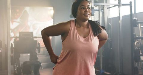 Confident african american woman stretching at gym during warmup for strength training