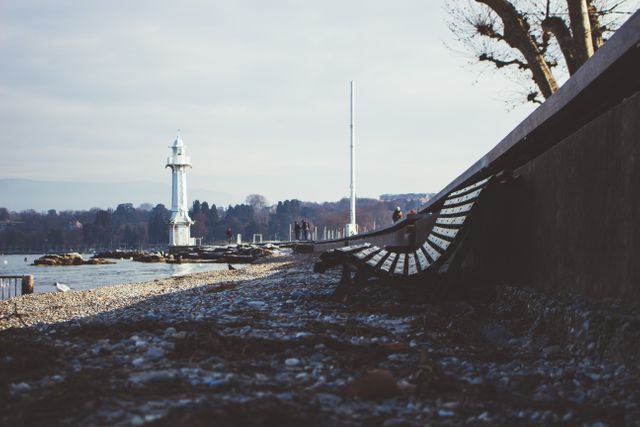 Tranquil Lakeside Promenade with Lighthouse and Bench in Winter - Download Free Stock Images Pikwizard.com