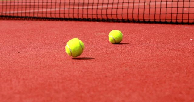 Two Tennis Balls on Red Court Near Net - Download Free Stock Images Pikwizard.com