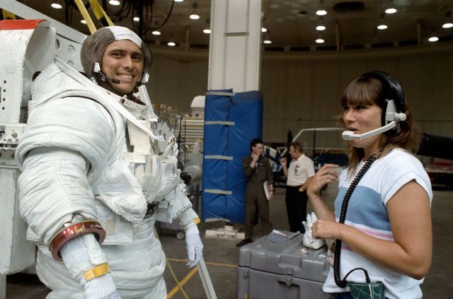 S89-42667 (24 Aug 1989) --- Astronaut Franklin R. Chang-Diaz tests his communications gear with Pam S. Peters of RSO, prior to participating in an underwater simulation of a contingency extravehicular activity (EVA) for his mission specialist assignment on NASA's STS-34 mission.  He stands on a platform that will lower him into  a 25-ft. deep pool, part of JSC's weightless environmental test facility (WET-F). Also participating in the contingency EVA rehearsal was astronaut Ellen S. Baker (out of frame).