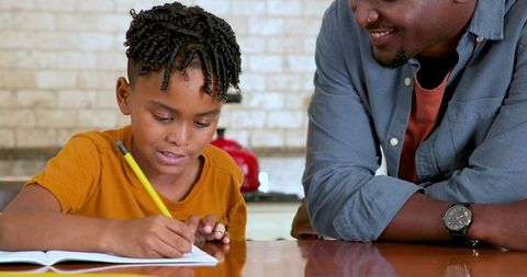 Father Assisting Son with Homework at Home for Education Success