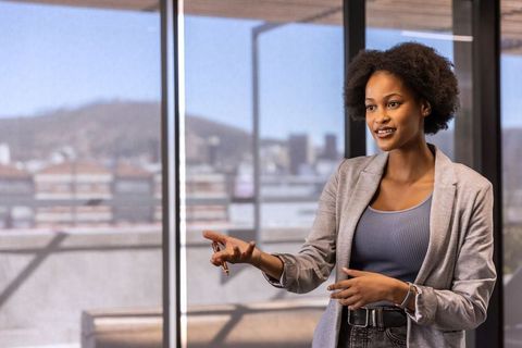 Confident Businesswoman Presenting in Modern Office Setting