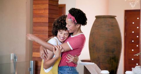 Joyful Friends Embracing at Home Celebrating Friendship and Happiness