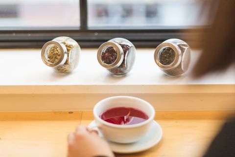 Selecting Herbal Tea with Three Glass Jars and Cup