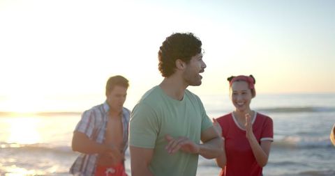 Joyful friends enjoying sunset beach gathering in slow motion